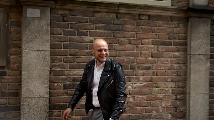 Collega van MSI loopt langs een bakstenen gevel