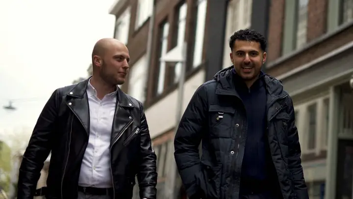 Twee collega's van MSI lopen samen door een winkelstraat