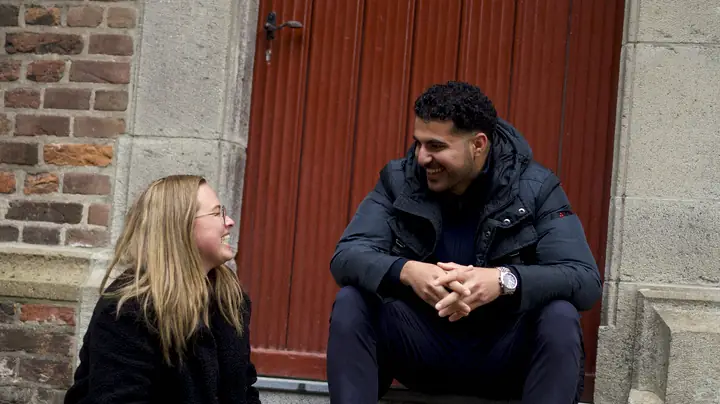 Twee collega's van MSI op het stoepje voor een rode voordeur